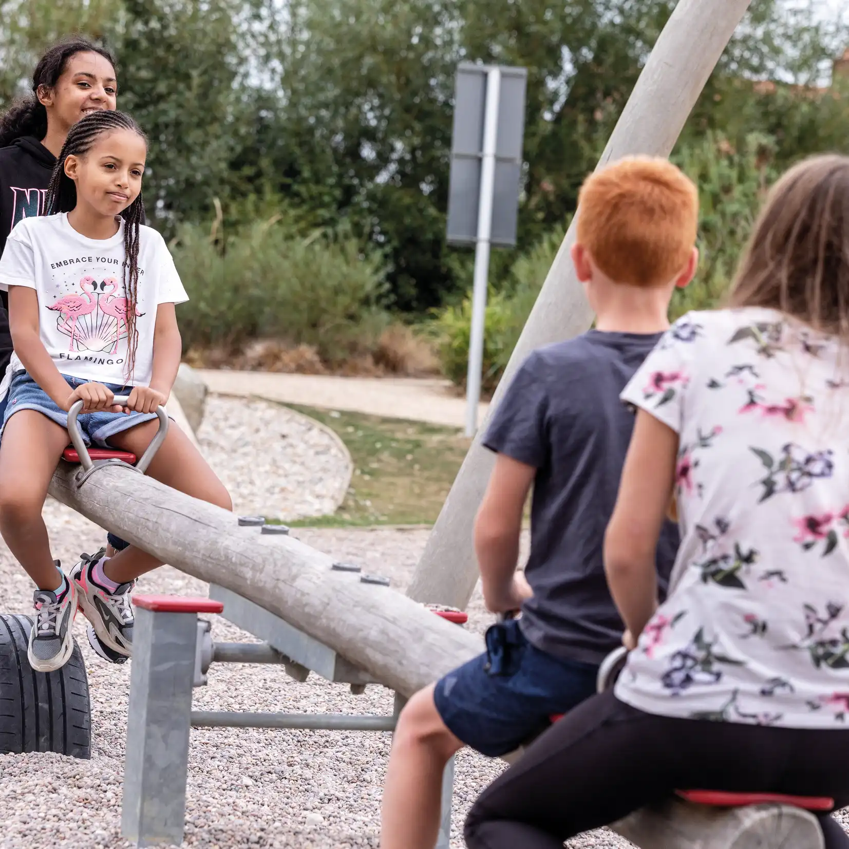 Children in a park, playing on a seesaw